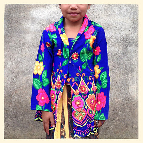 Bocah perempuan di daerah Sembalun yang terletak di kaki Gunung Rinjani, Lombok, Nusa Tenggara Barat, mengenakan baju bermotif warna-warni saat menghadiri upacara adat Mengayu Ayu.