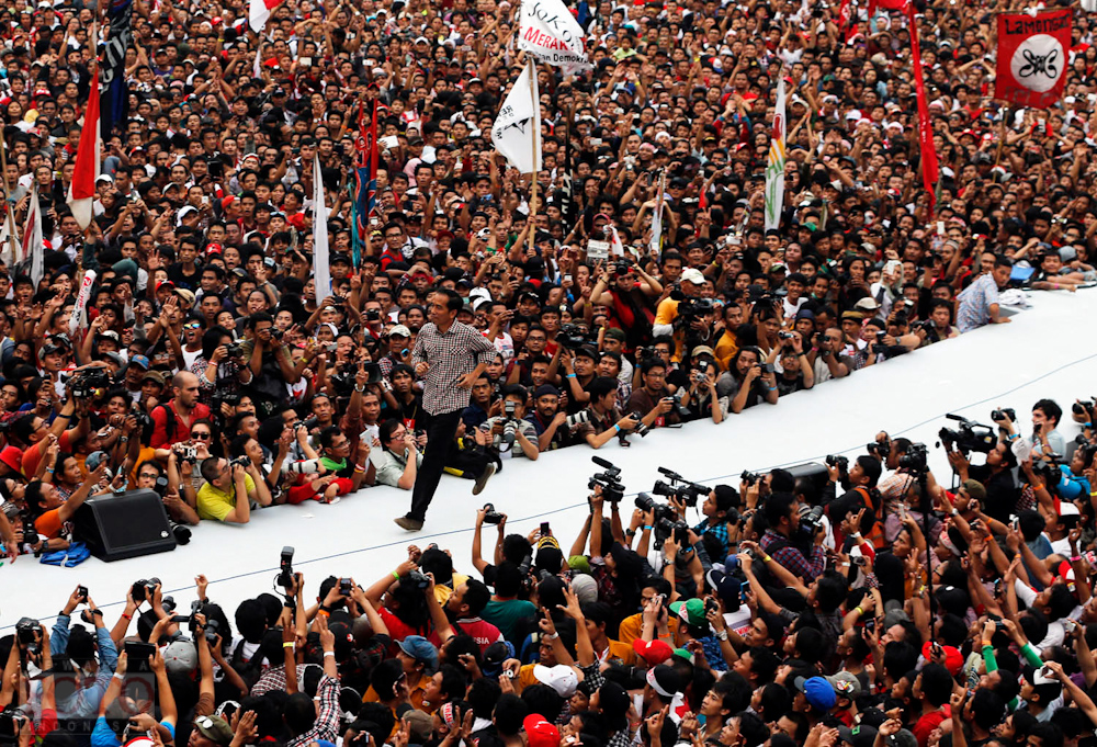 Indonesian presidential candidate Joko "Jokowi" Widodo runs on the stage after delivering a speech in front of his supporters at Gelora Bung Karno stadium in Jakarta