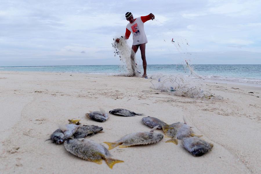 Bohe (70 tahun) , seorang suku bajau , merapikan jaring seusai menangkap ikan di gosong Kabak Tengah, Pulau Derawan