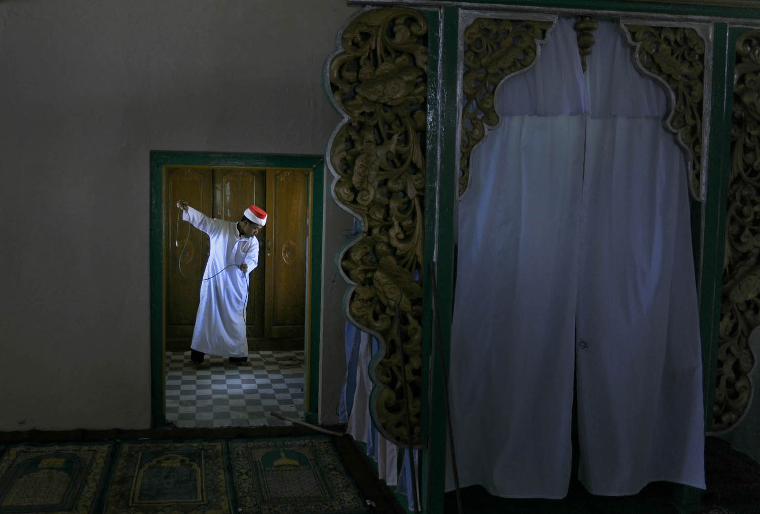 Seorang Moding (pengurus keagamaan di sultan Ternate) merapikan kabel pengeras suara setelah shalat jumat di Masjid Sultan Ternate
