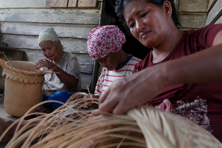 Wanita suku dayak mengayam keranjang di kampung dayak Teluk Sumbang, Biduk Biduk, berau